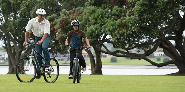 Father and son on bikes in park