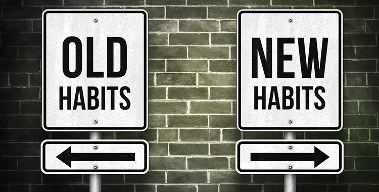 Two signs saying old habits and new habits pointing in different directions.