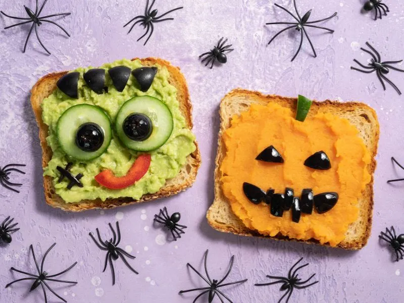 Creative monster-themed Halloween toasts with vegetables, featuring Frankenstein and Jack-o-lantern designs.