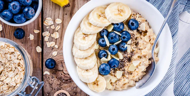 Whole grain porridge in a bowl with banana and blueberries