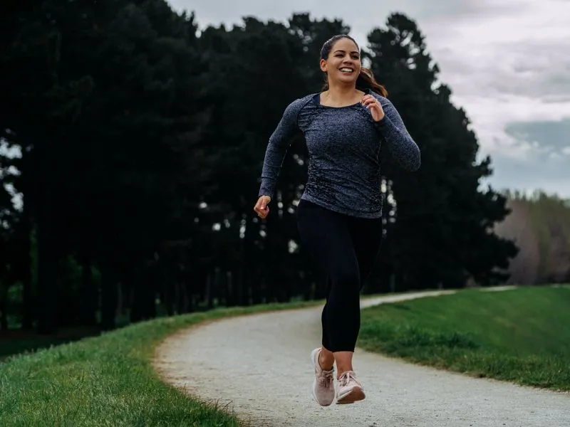 Image of a woman in trainers running on a jogging track, symbolising the start of a new year and healthy goal setting.