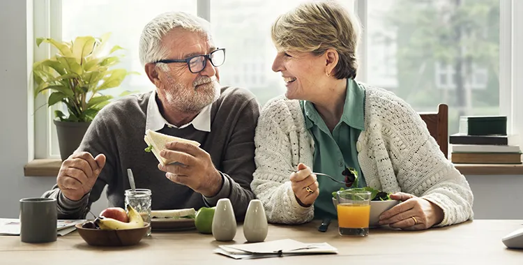 Couple sitting at table eating healthy food