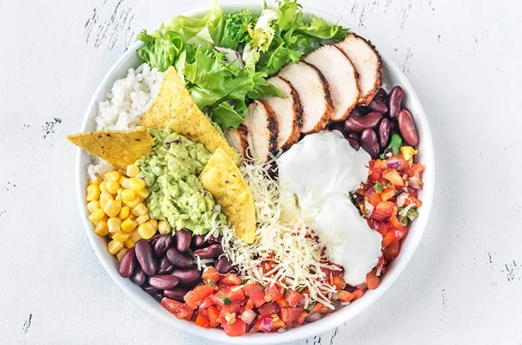 A bowl of fresh vegetables, whole grains and protiens