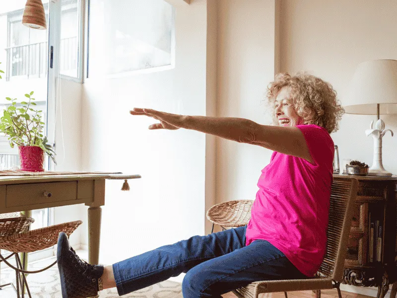 Older adult doing chair exercises at home to stay active and improve heart health.
