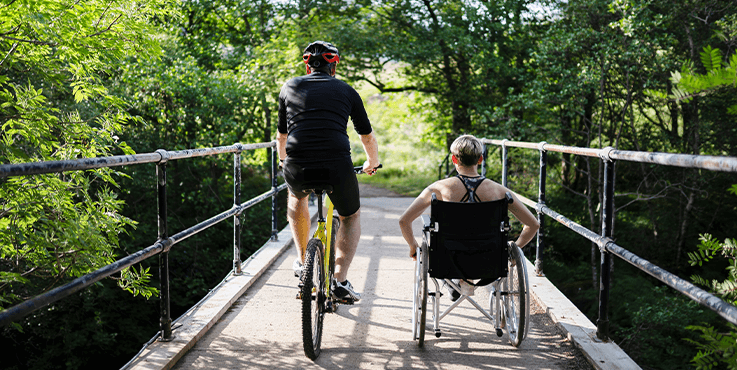 two men walking with one on a wheelchair