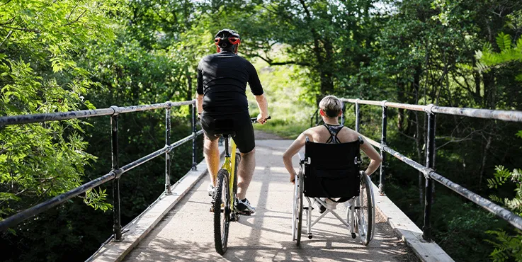 two men walking with one on a wheelchair