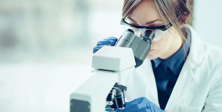 Scientist using microscope in lab