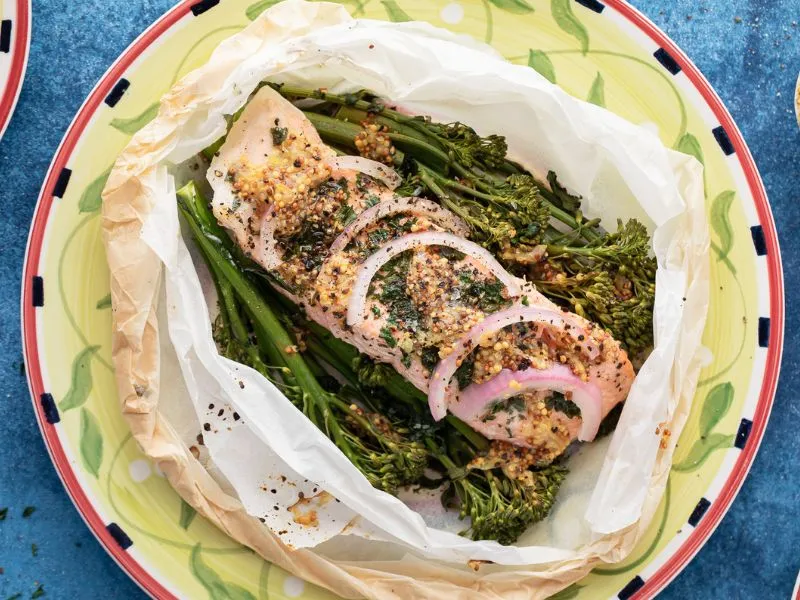 A picture of salmon parcel served on a plate on top of a blue table