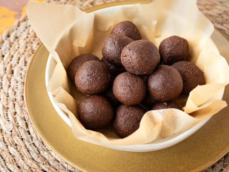 a table with a bowl full of oaty banana balls