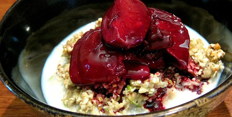 Apple and oat muesli topped with poached plums