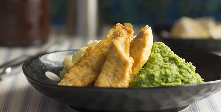 Healthy and warm plate of battered fish and pea puree