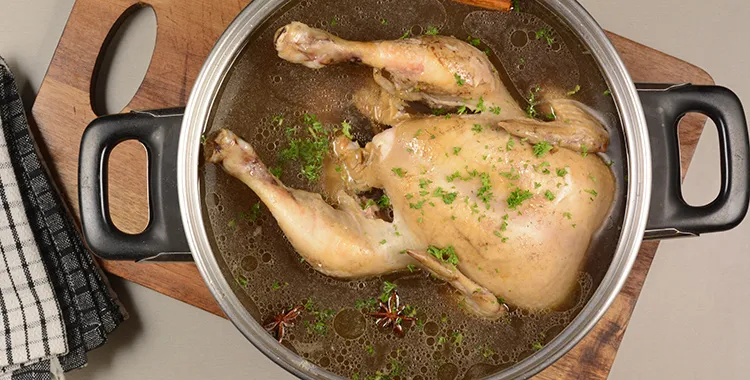 Seasoned chicken in pan of stock