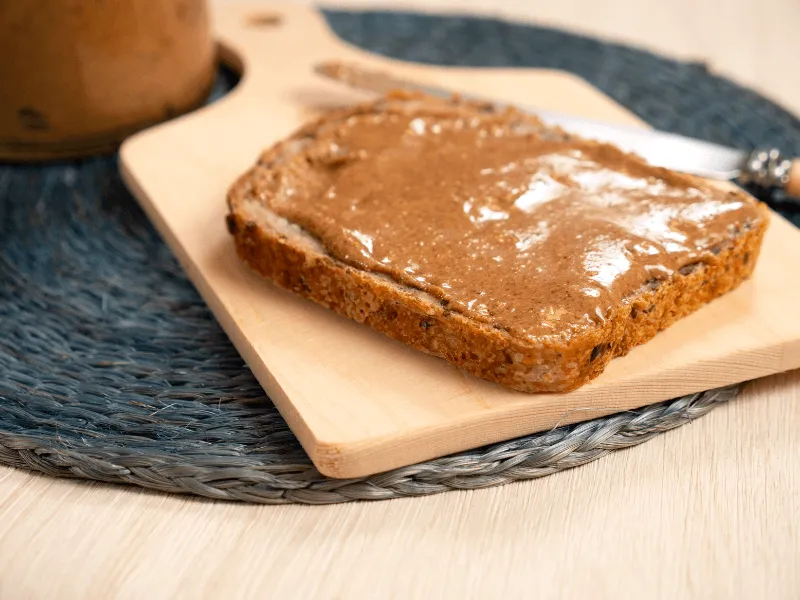 Nut butter spread on whole grain toast—smooth, creamy, and made from blended roasted nuts, enjoyed as a nutritious topping for breakfast or snacks.