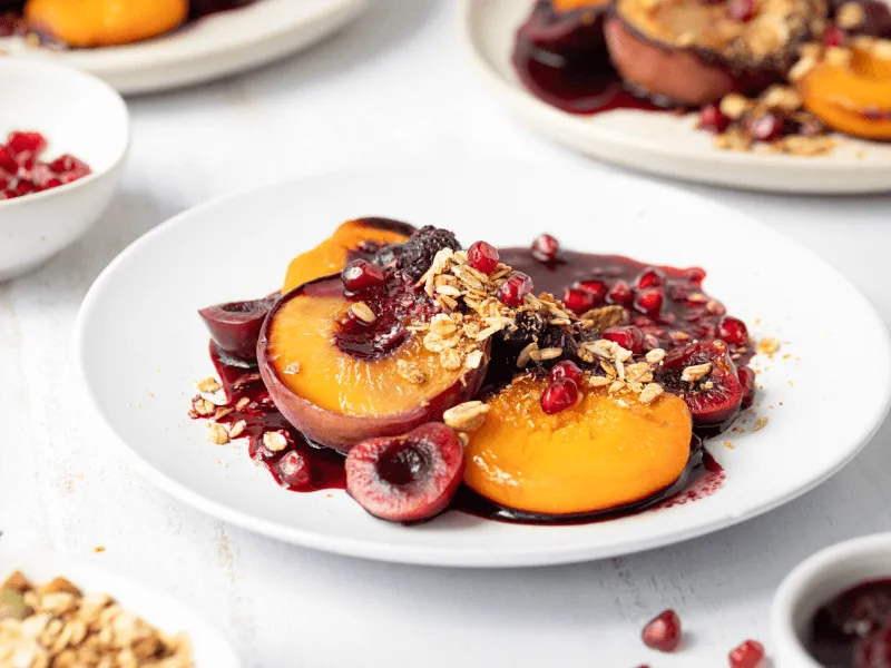 Bowls of roasted fruit crumble on a table.