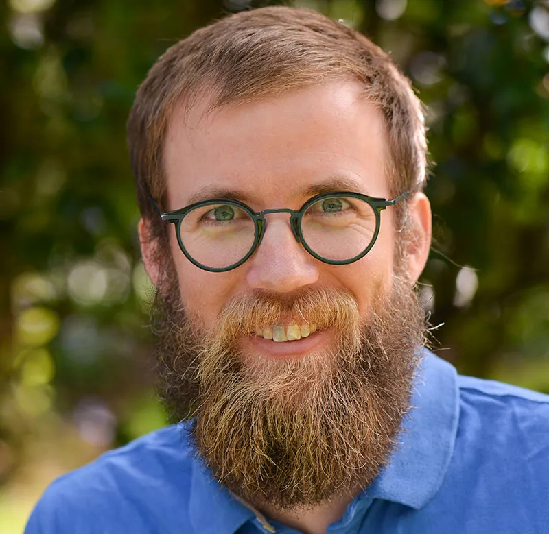 Dr Rory Miller - University of Otago Senior Lecturer and Director Rural Postgraduate Programme. Rory wears black round-rimmed glasses and a blue shirt. He has a full beard.