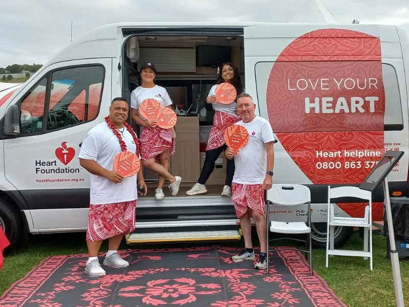 Heart Health Advocates and Pacific Heartbeat team posing for a picture along with the stand strong banner and love your heart van