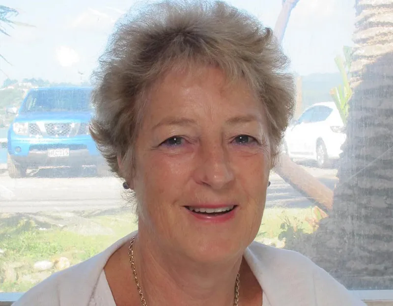 Jocelyn Bell wears a white top and sits in front of a window.