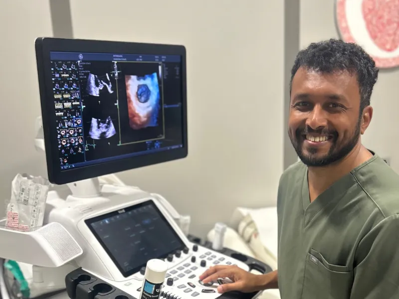 Dr Rahul Gandhi using cardiac ultrasound equipment to review detailed images of the heart.