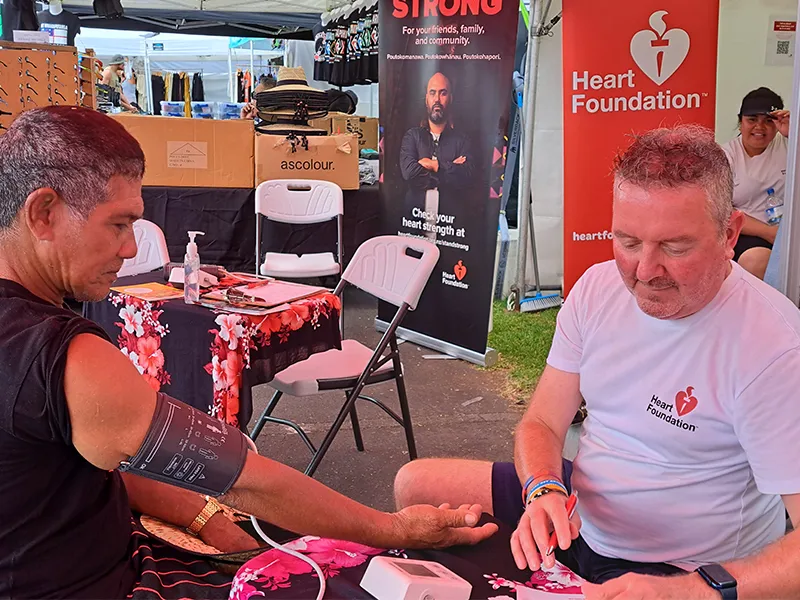 Man getting a blood pressure check at stand strong campaign tent.