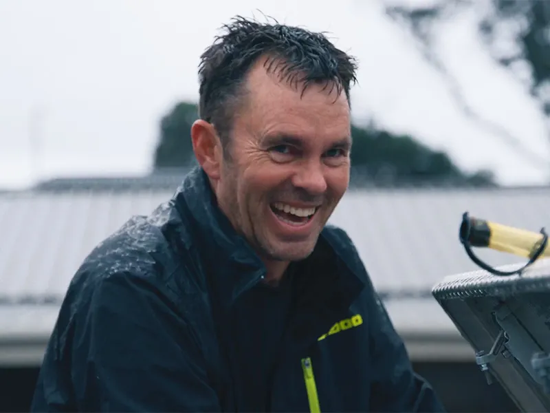 Andrew Hill appears to be laughing - he is wet, as though he has just come out of the sea or has been caught in heavy rain.