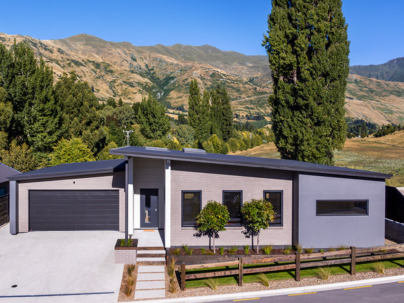 Contemporary single-story house in Wanaka with mountain views, landscaped front yard, and double garage.