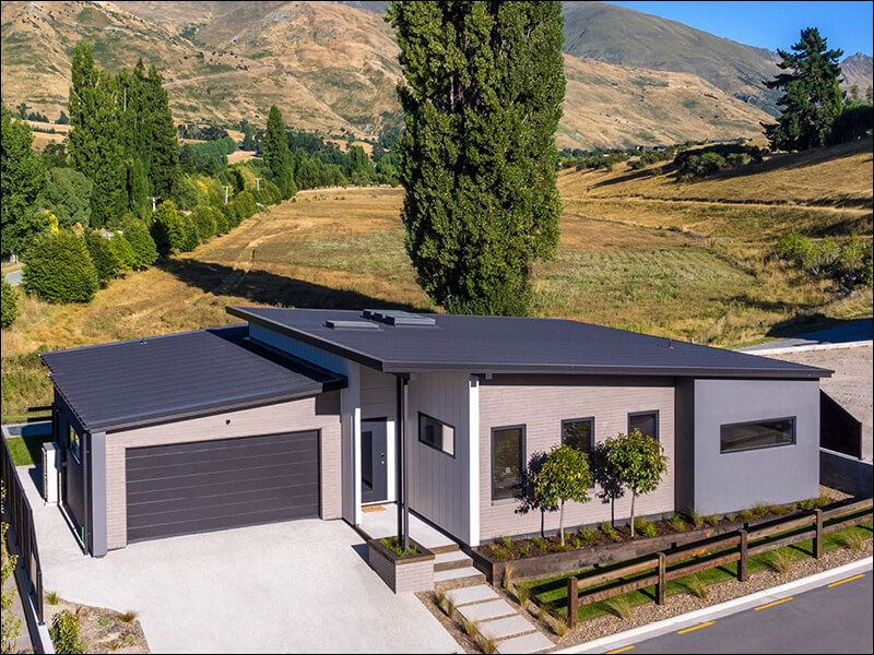 Contemporary single-story home in Wanaka with double garage, landscaped front yard, and panoramic mountain views