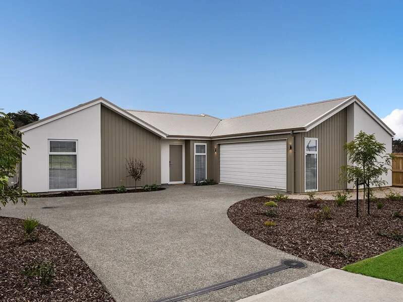 Contemporary single-level house exterior with double garage, landscaped driveway, and neutral color palette.