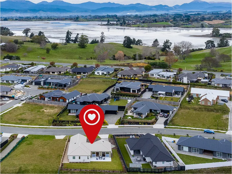 Aerial photograph highlighting property location within a residential area near water and scenic hills.