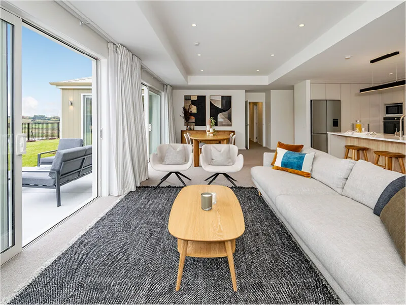 Open-plan living and dining area with sliding glass doors leading to an outdoor patio and garden.
