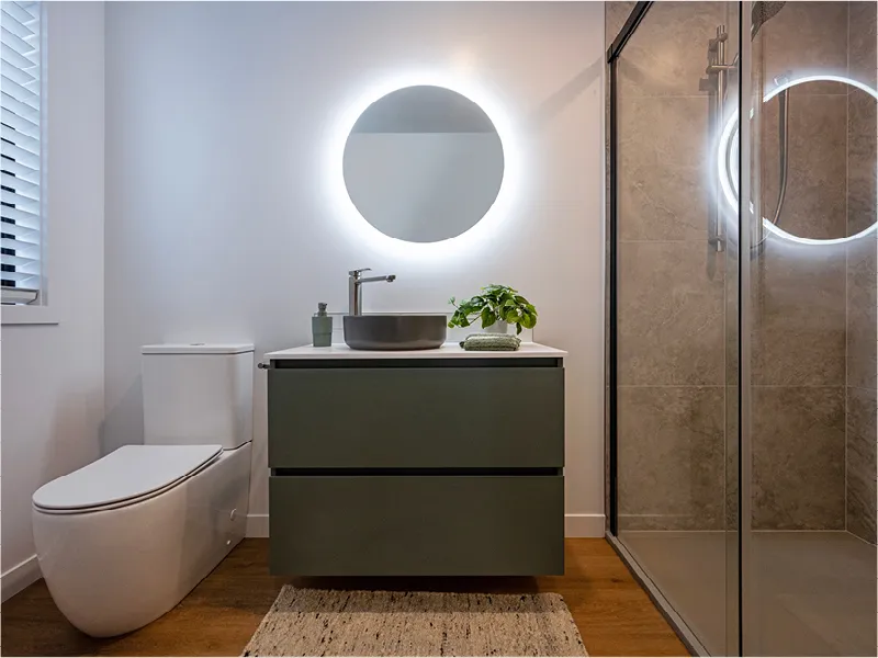 Guest bedroom in the Napier home featuring rust-coloured bed frame, white bedding with warm-toned cushions, and modern bedside lighting.