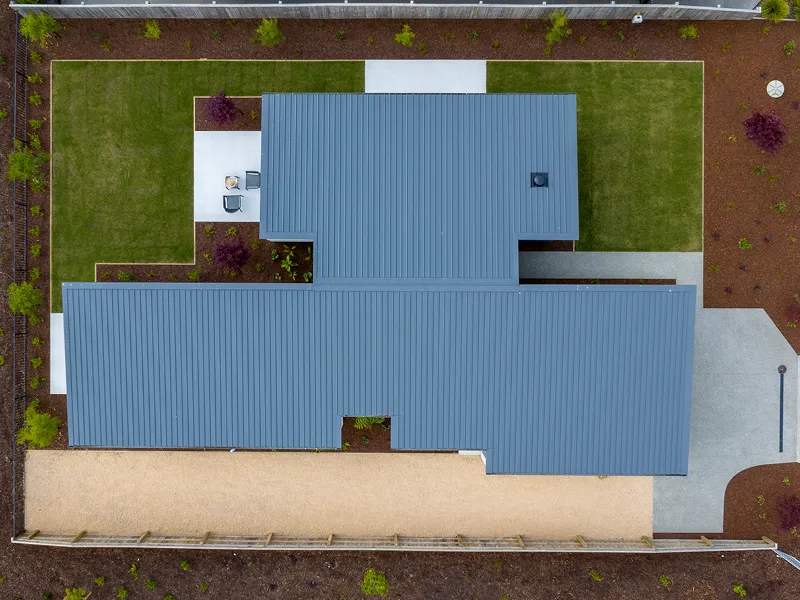 Aerial view of the Heart Foundation Home Lottery 162 three-bedroom house in Richmond, Nelson showing roofline, landscaped gardens and outdoor patio.