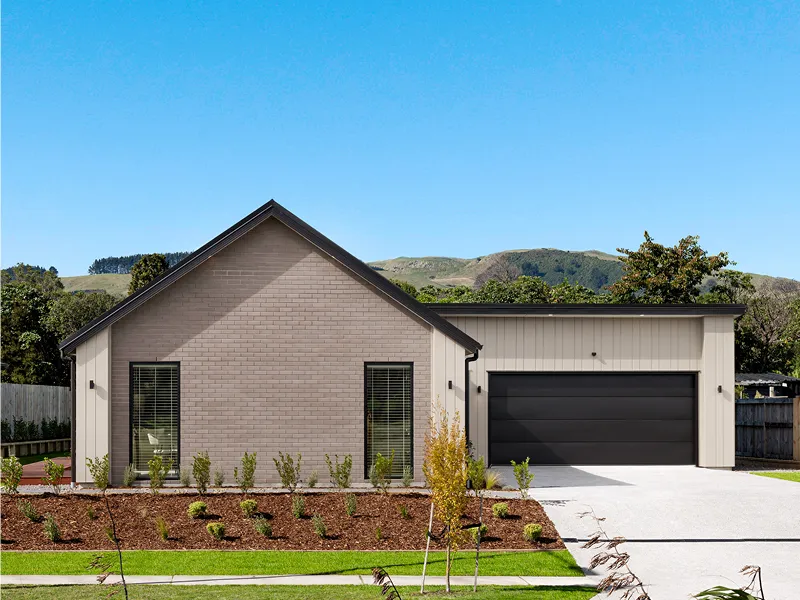 Front exterior of modern Kinloch house with brick cladding, double garage, neat landscaping and hills in the background.