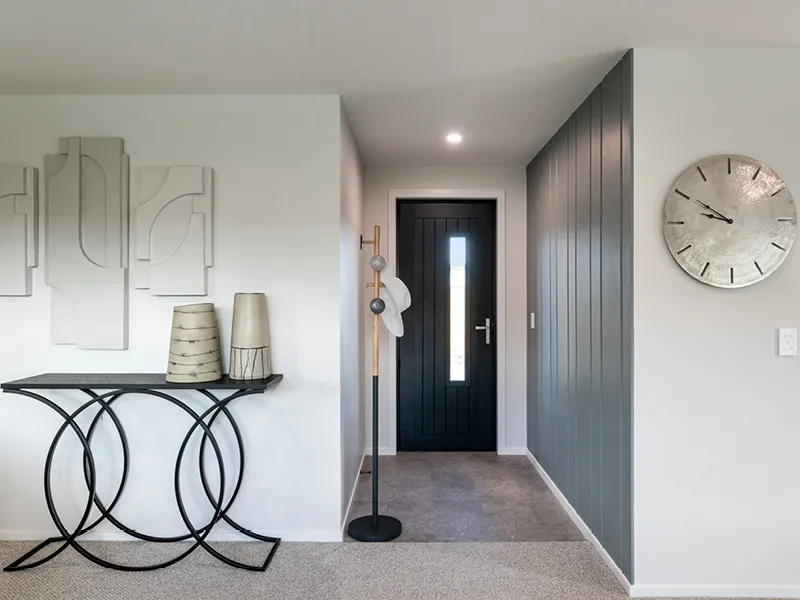 Stylish Kinloch entry hallway with black front door, feature wall panelling, wall art and contemporary console table.