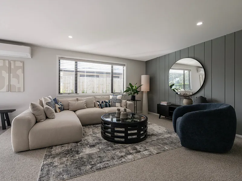 Contemporary Kinloch living room with large sectional sofa, round coffee table and feature wall with circular mirror.