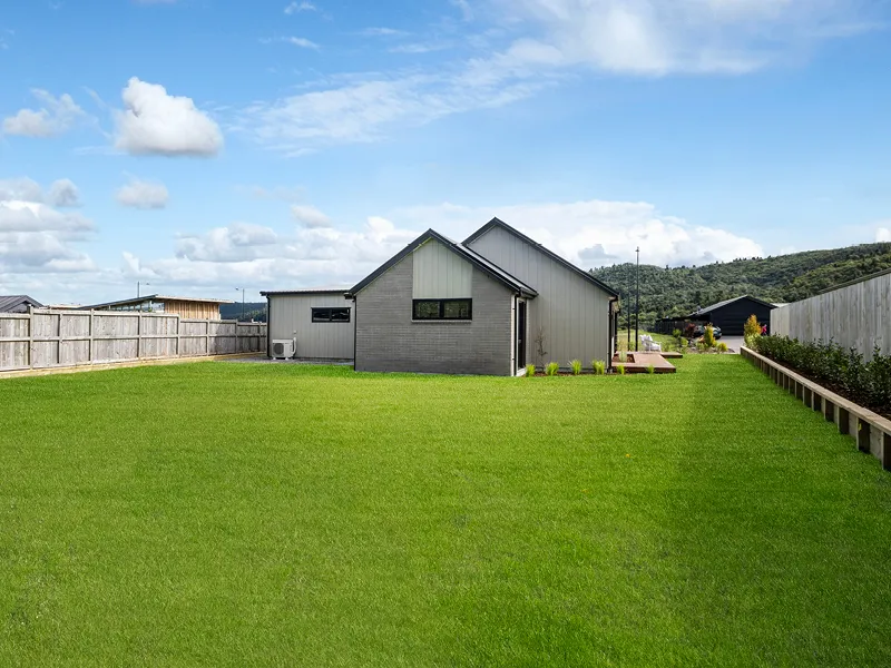 Large flat backyard and rear elevation of Kinloch home with fenced boundary and lawn.