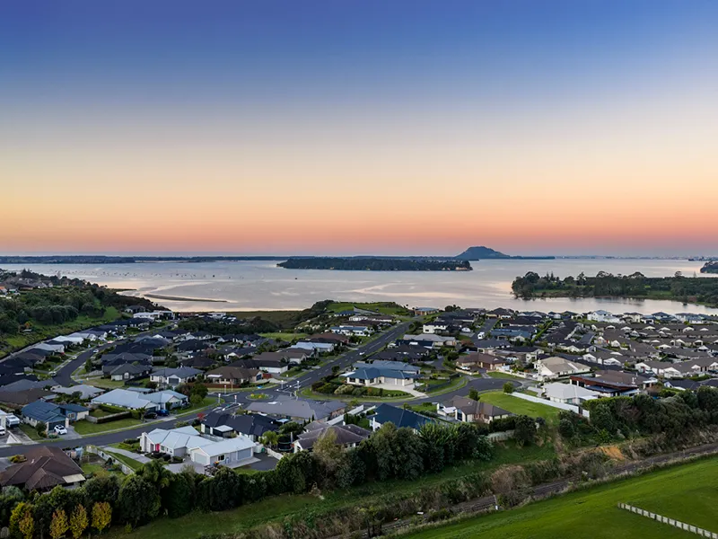Aerial sunset view of Ōmokoroa coastline and Tauranga Harbour near the Heart Foundation Home Lottery No. 165 house.