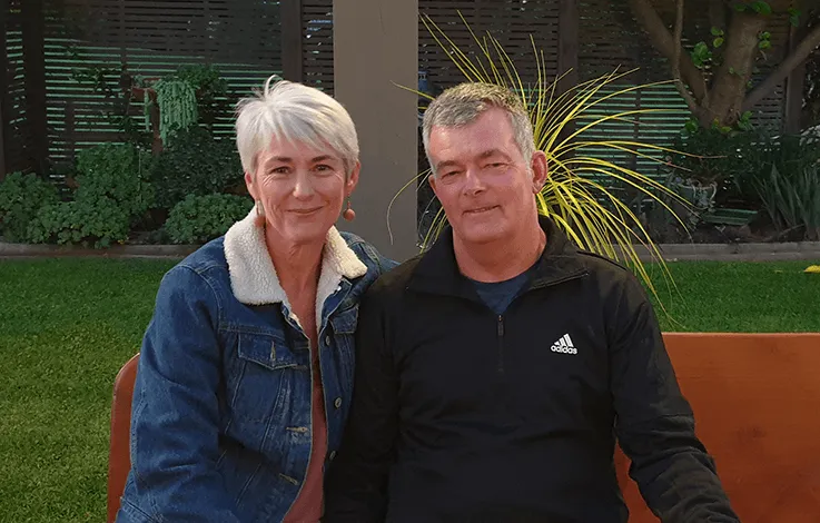 Photo of Tonya Jones and her husband Lance, sitting at an outside table in their garden. 