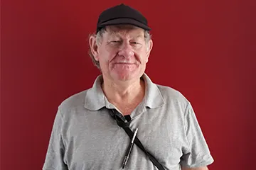 Photo of Trevor Cooper standing in front of a red wall.