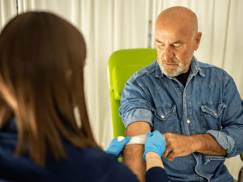 Nurse preparing a patient for a blood test in a medical clinic.