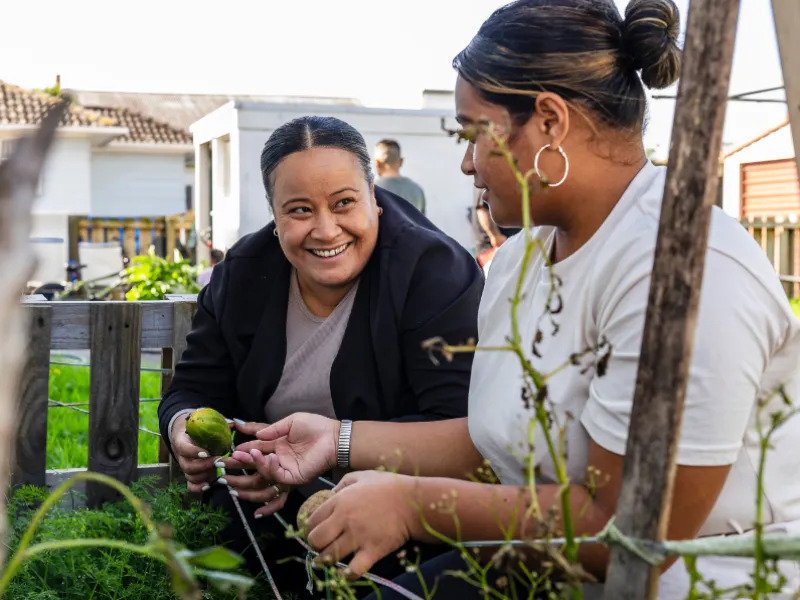 People sharing gardening skills in a community vegetable garden