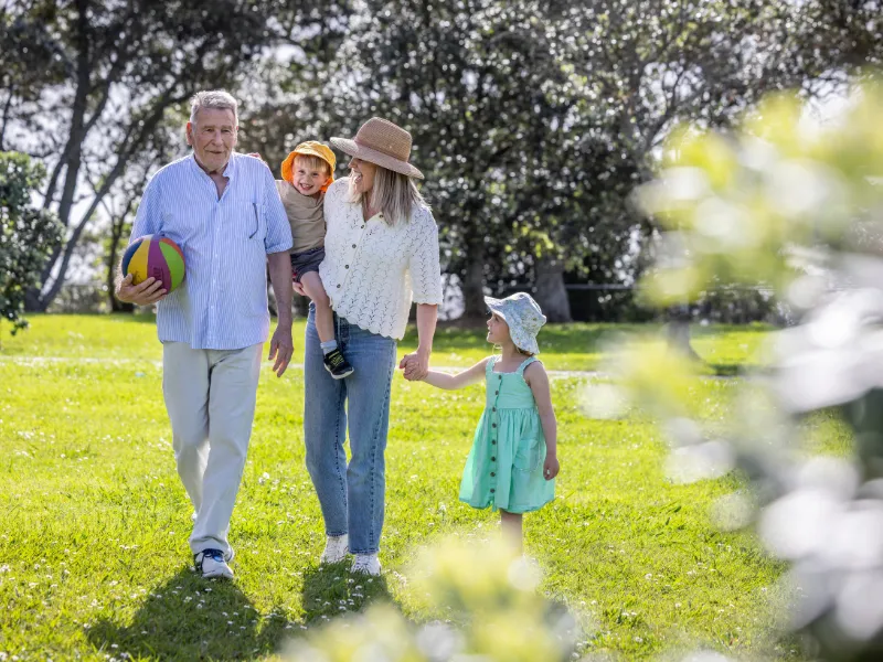 A couple walking together with a young child holding hands