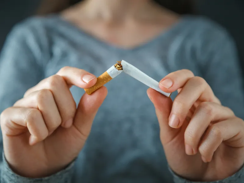 Person breaking a cigarette in half to quit smoking and support better heart and lung health.