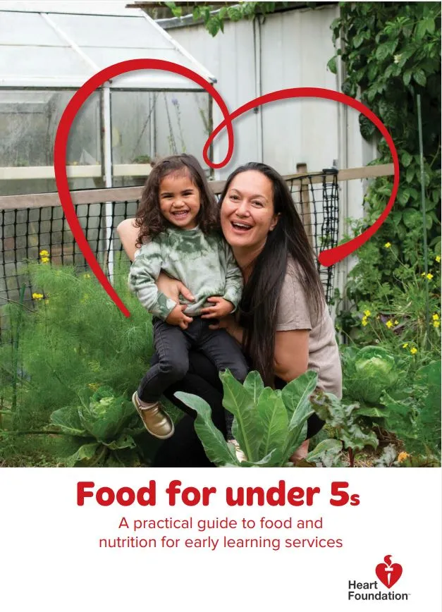 The image features a smiling adult and young child sitting together in a lush vegetable garden, framed by a large red heart illustration. The Heart Foundation logo appears at the bottom of the cover.
