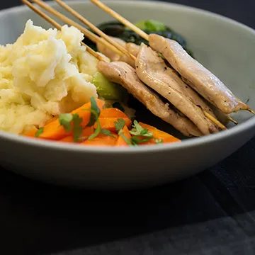 grilled chicken on skewers with steamed vegetables